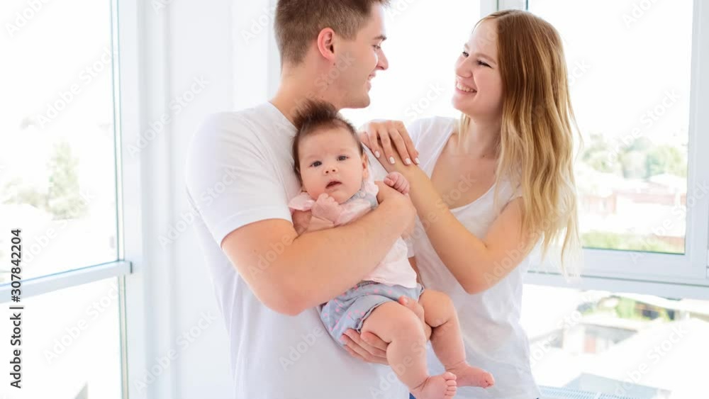 Happy family standing togehter in light room Happy family standing togehter in light room
