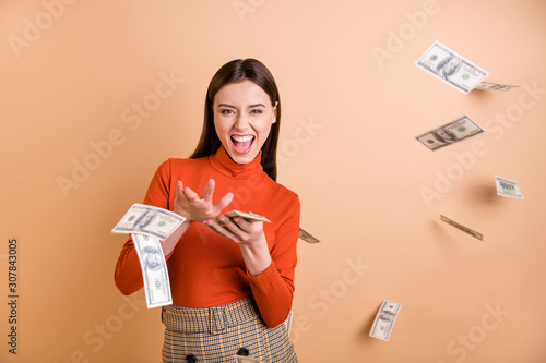 Portrait of her she nice attractive lovely pretty cool cheerful cheery confident straight-haired girl throwing money away isolated over beige pastel color background photo