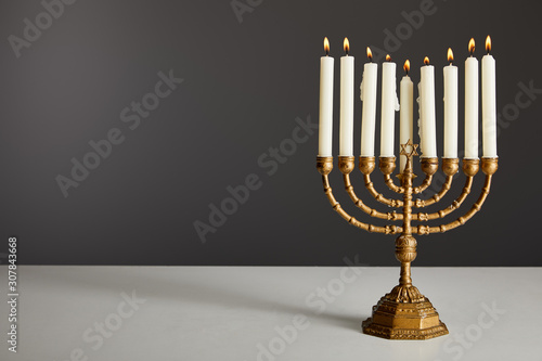 burning candles in menorah isolated on grey