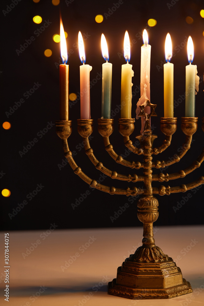burning candles in menorah on black background with bokeh lights on Hanukkah burning candles in menorah on black background with bokeh lights on Hanukkah