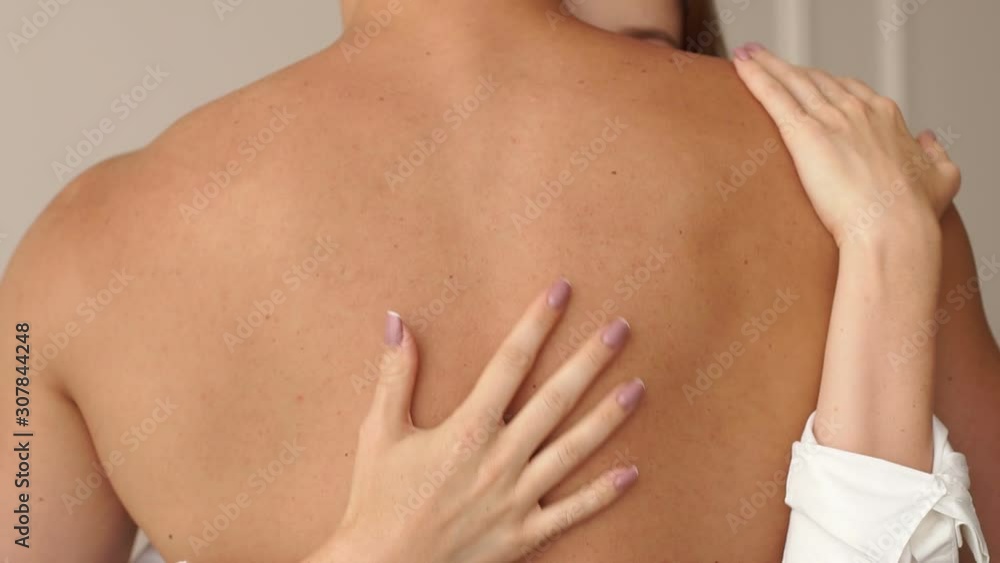 Close-up of a girl passionately embracing her boyfriend behind his naked back, a young couple having sex. Close-up of the girl's hands on the man's back. Sexual relations between a man and a woman. Close-up of a girl passionately embracing her boyfriend behind his naked back, a young couple having sex. Close-up of the girl's hands on the man's back. Sexual relations between a man and a woman.