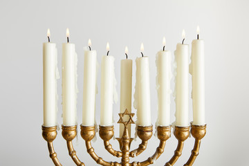 Burning candles in menorah on Hanukkah isolated on white