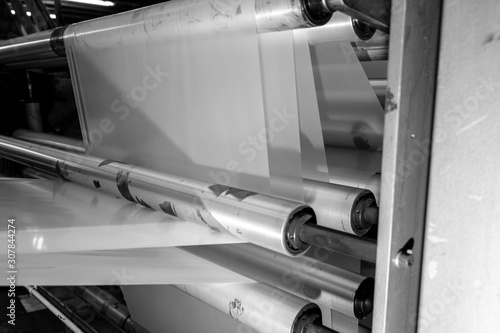 imagery White spool of plastic packaging sheet heavy duty for industrial use outdoors. wrapped around a metal pole ready to feed into a machine for cutting into shape or printing logos.