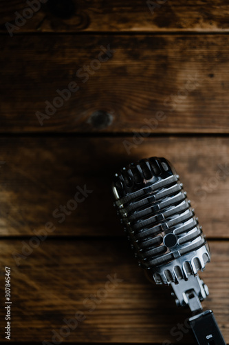 Retro microphone on dark wooden background