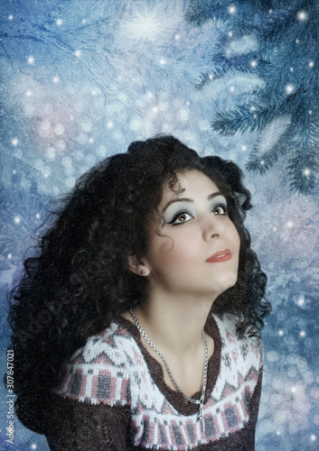 Young dreamy girl in the winter forest on New Year`s Eve looking at the falling snow © nizhava1956