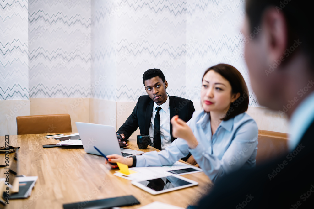 Diverse office colleagues sitting at workplace Diverse office colleagues sitting at workplace