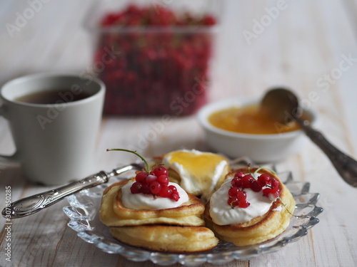 frozen berry red currant, honey, tea and pancakes on a wooden white tableOLYMPUS DIGITAL CAMERA
