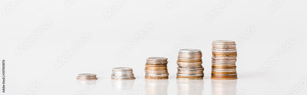 panoramic shot of stacks of silver and golden coins on white panoramic shot of stacks of silver and golden coins on white