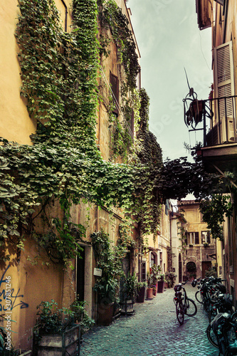 Fototapeta Naklejka Na Ścianę i Meble -  Narrow street in Rome with cobble stone and bicycles