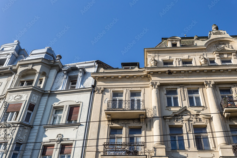 Two vintage buildings in a dense urban area with decorative facades
