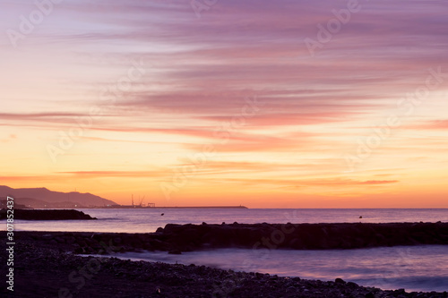 Sunrise seascape on Cubelles shore with Vilanova i la Geltru on background © Photojope