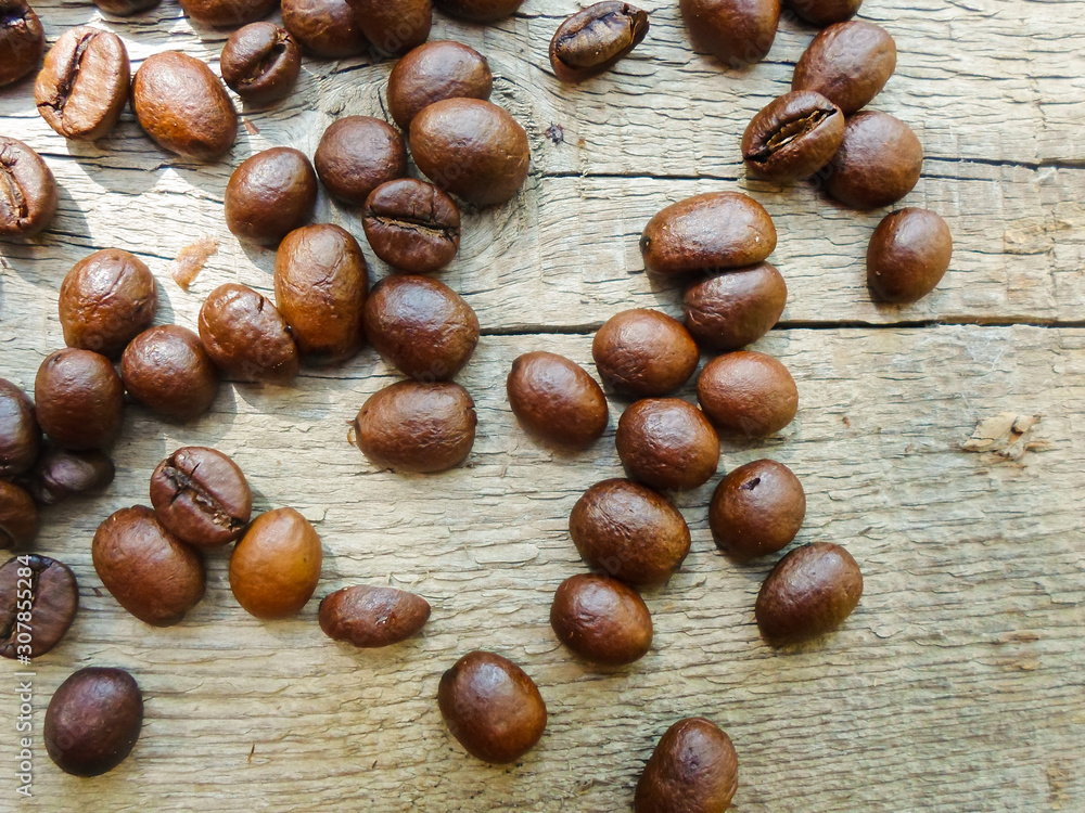 large grains of coffee on a wooden table. place for text large grains of coffee on a wooden table. place for text