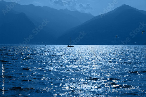 Boat in the mountain lake. District of Como Lake, Colico, Italy, Europe. Evening light. Trendy color of the year 2020.