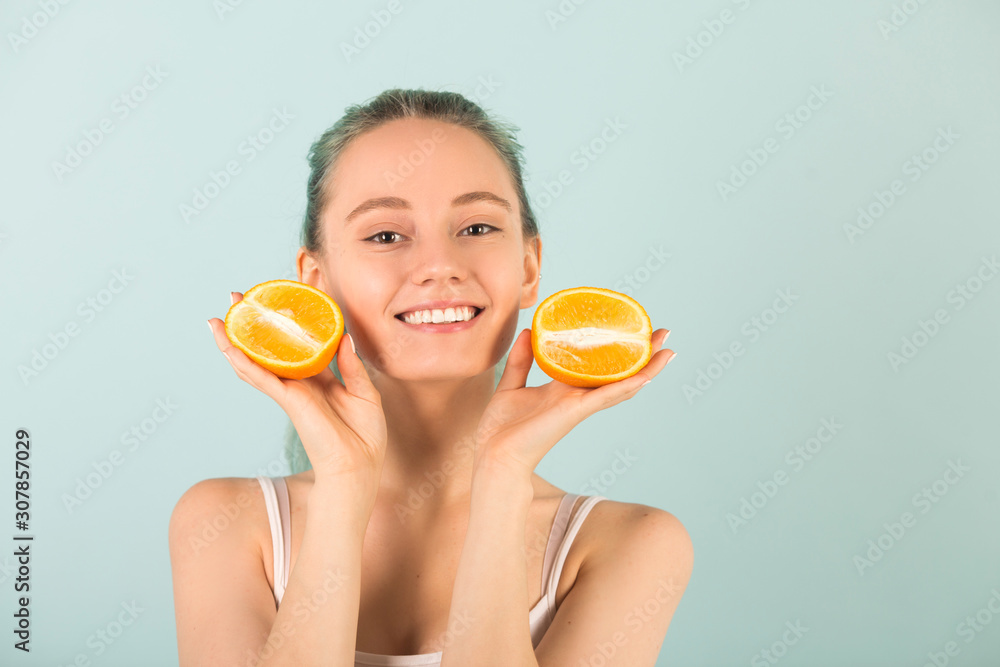 beautiful slender young woman in sportswear with oranges in her hands