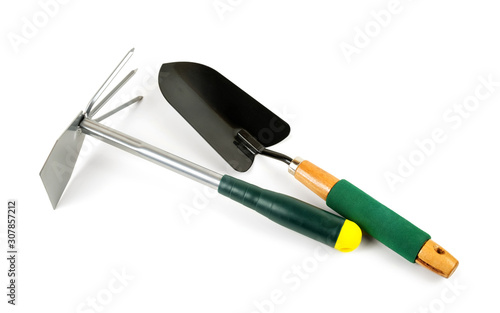 Shovel with green handle and garden tool with rakes and hoe