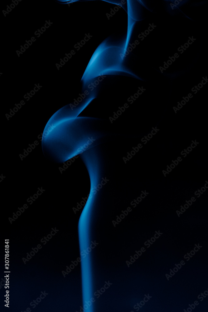 Silhouette of a woman from the smoke of incense sticks trendy classic blue on a dark background. Silhouette of a woman from the smoke of incense sticks trendy classic blue on a dark background.