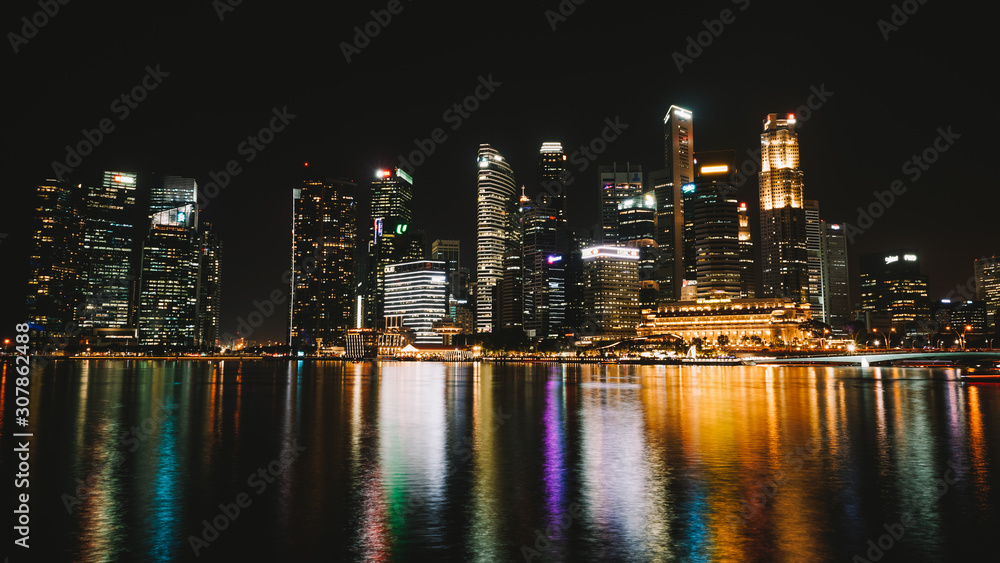La ville de Singapour de nuit avec les reflets des lumières sur le fleuve