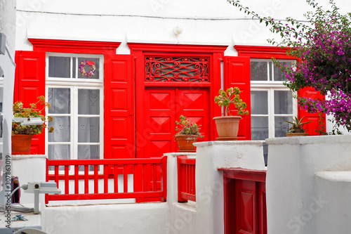 Fototapeta Naklejka Na Ścianę i Meble -  one of the charms of Mykonos, Greek Cycladic island in the heart of the Aegean Sea, are the beautiful colored doors and windows of the houses in the narrow streets of the ancient city