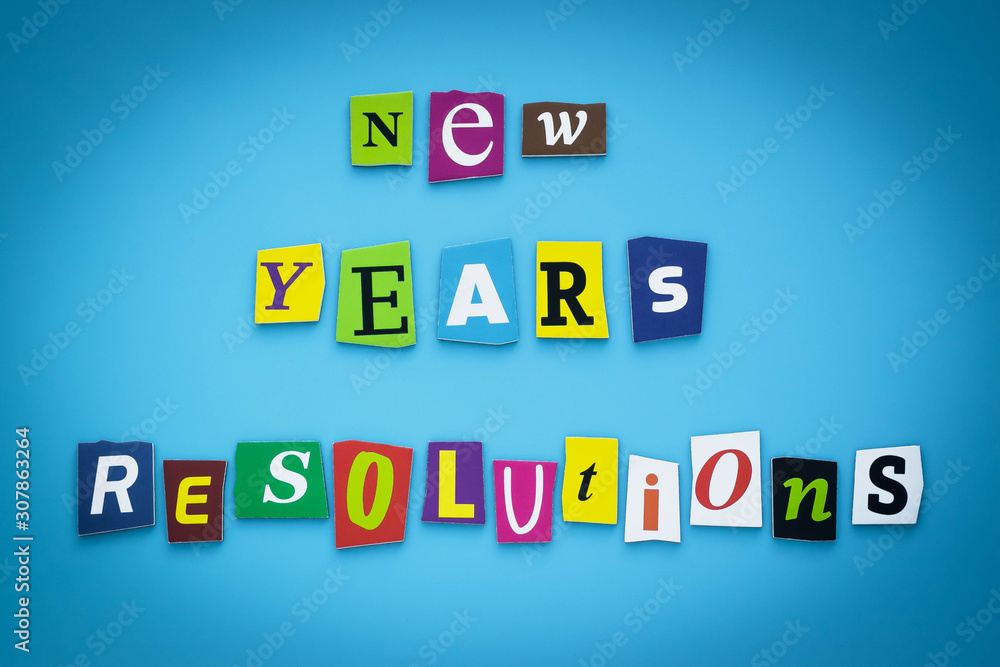 Text - New year's resolutions. Cut colorful letters on blue background. Writing on banner, card. Inscription, message on poster.