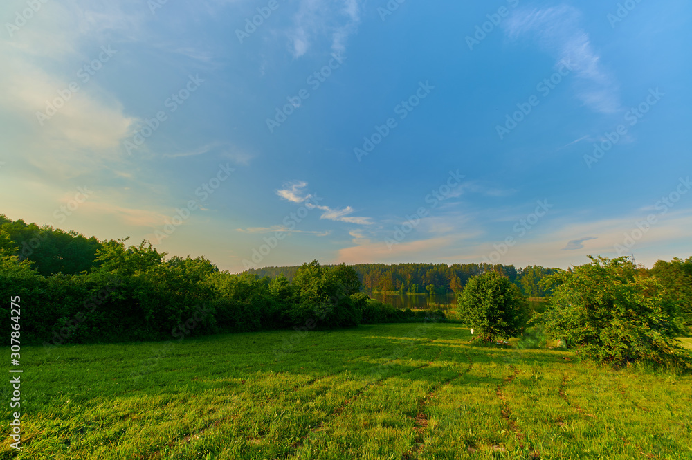 Peaceful rural summer european landscape with green trees and water