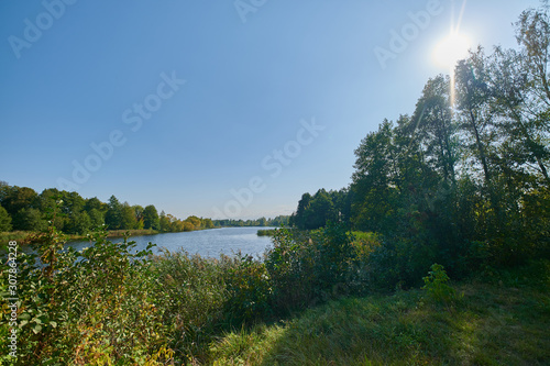 Fototapeta Naklejka Na Ścianę i Meble -  Peaceful rural summer european landscape with green trees and water