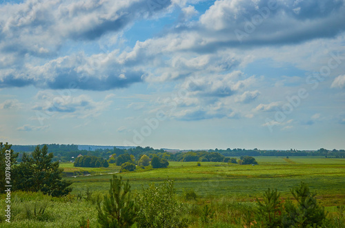 Peaceful rural summer european landscape with green trees and water