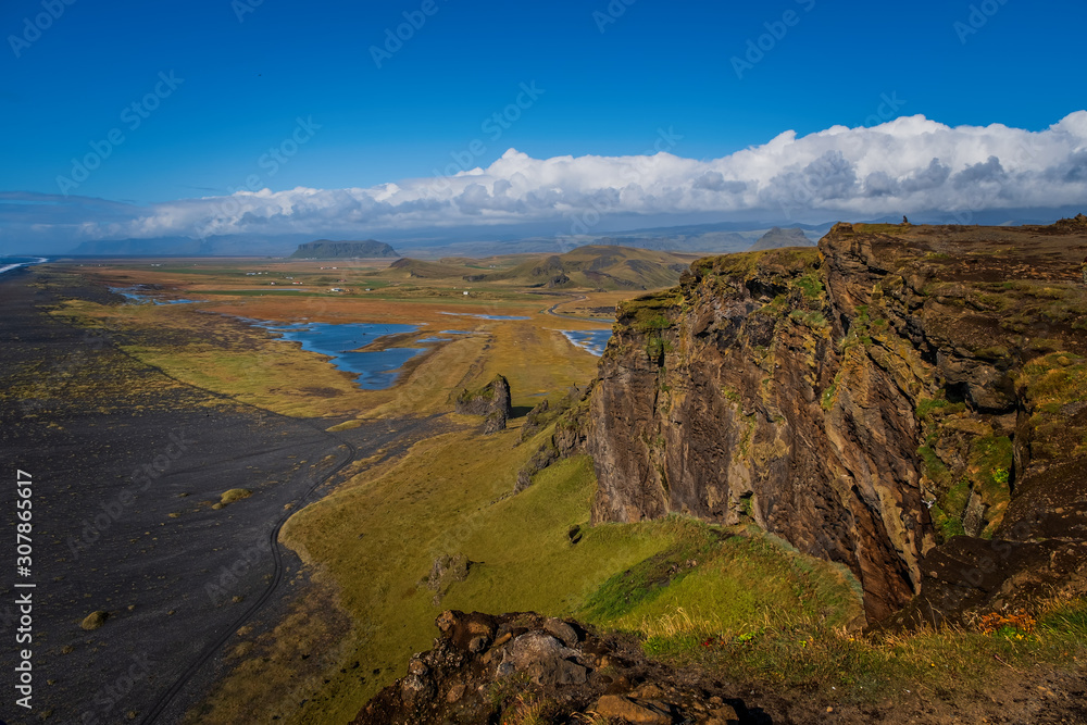 Reynisfjara Black Sand Beach, found on the south coast of Iceland near the village of village of Vik i Myrdal, seen from a cliff during a sunny day. September 2019