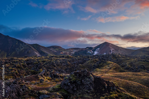 Iceland in september 2019. Great Valley Park Landmannalaugar  surrounded by mountains of rhyolite and unmelted snow. In the valley built large camp. Evening in september 2019