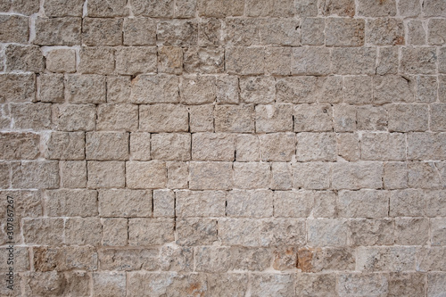 Old masonry of light rectangular blocks, southern Italy.Background.