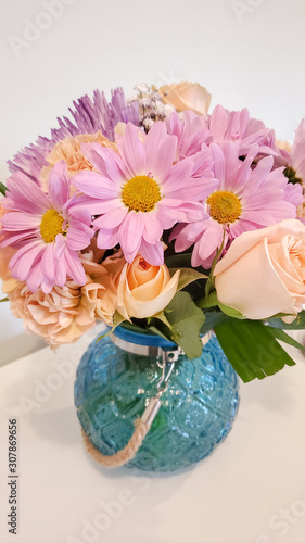 Vase with beautiful aster flower bouquet on table against color background. 