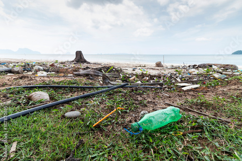 Empty used dirty plastic bottles on the seaside. Ecological problem and environmental pollution.