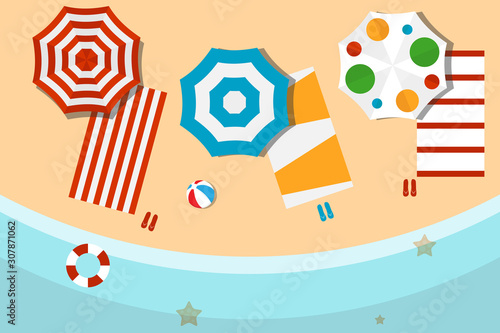 Beach with umbrellas, beach towels and flip flops. The concept of relaxing on the beach. Beach with sand and sea waves.
