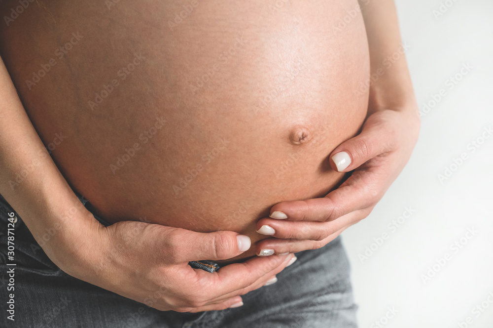 Attractive pregnant woman holding her belly. Last months of pregnancy Attractive pregnant woman holding her belly. Last months of pregnancy