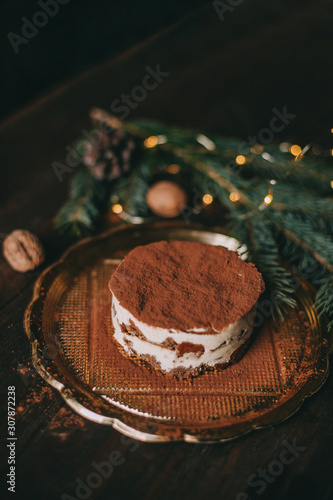 Christmas dessert - tiramisu on wooden background with Christmas tree and bokeh