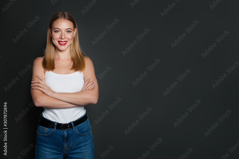Friendly smart blonde woman with crossed arms on gray background with copy space Friendly smart blonde woman with crossed arms on gray background with copy space
