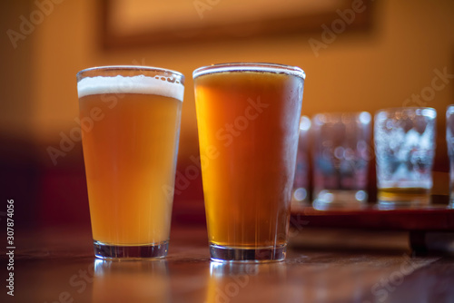 two pints of craft beer on bar counter at night