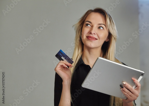 woman with credit card shopping online on digital tablet while lying at home