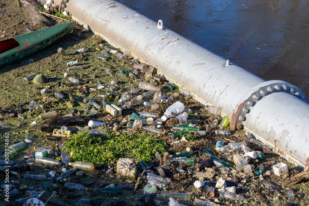 Plastikabfall in einem Fluss an einem Abwasserrohr Plastikabfall in einem Fluss an einem Abwasserrohr