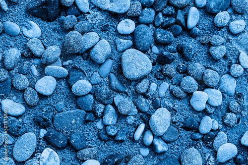 Pebble on the sand after rain. Color of the year 2020 classic blue toned. Top view, beach © Laima Gri