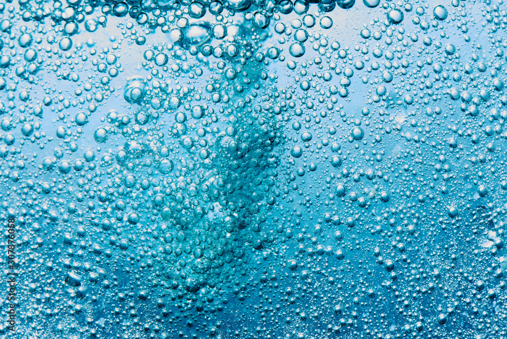 Sparkling Mineral Water Background. Blue bubbles of fresh soda float to the surface of drink to quench your thirst Sparkling Mineral Water Background. Blue bubbles of fresh soda float to the surface of drink to quench your thirst