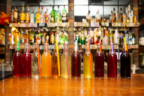 Plenty little bottles with alcohol drinks. Mini bottles with alcohol tinctures at the bar.