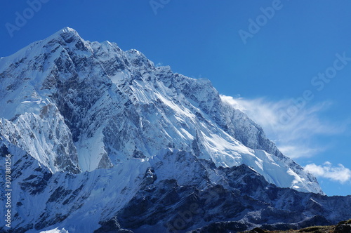 The top of snow-covered mount in the background of blue sky in the Himalayan mountains. Nepal.