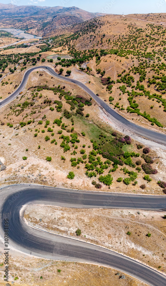 Aerial view of Kahta Sincik Road, close to Katha river near the village of Taslica, District of Kahta, Adiyaman Province, Turkey. Winding roads surrounded by nature with cars and vehicles