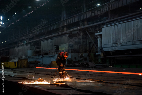 Worker doing a industrial welding at a steel mill