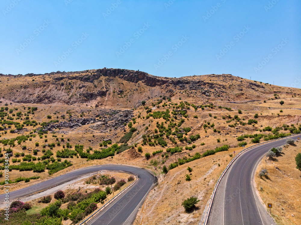 Aerial view of Kahta Sincik Road, close to Katha river near the village of Taslica, District of Kahta, Adiyaman Province, Turkey. Winding roads surrounded by nature with cars and vehicles Aerial view of Kahta Sincik Road, close to Katha river near the village of Taslica, District of Kahta, Adiyaman Province, Turkey. Winding roads surrounded by nature with cars and vehicles