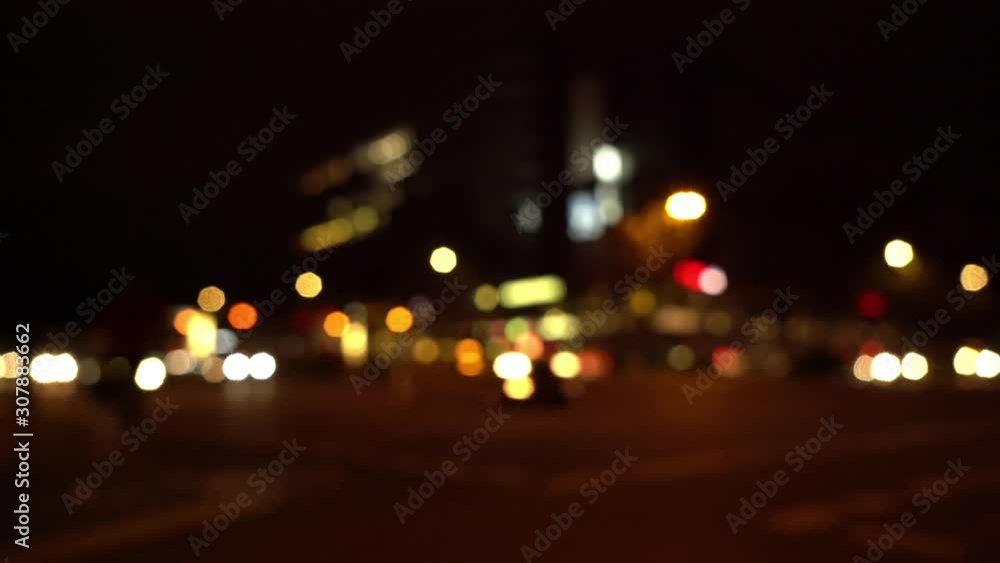 Defocused view of intersection in Berlin at night with oncoming traffic Defocused view of intersection in Berlin at night with oncoming traffic