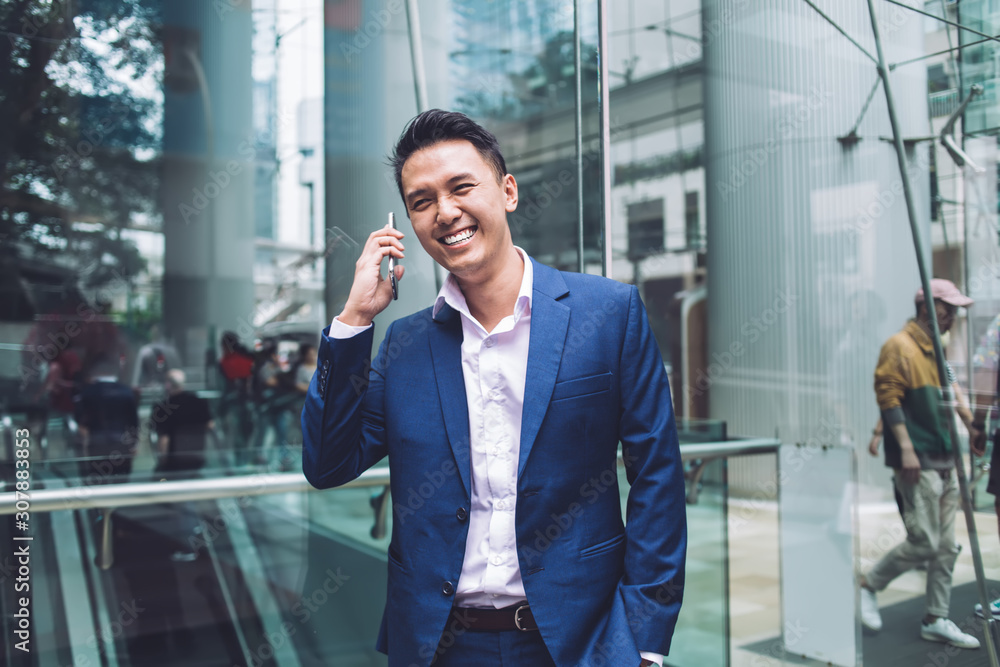 Handsome Asian businessman laughing talking on phone Handsome Asian businessman laughing talking on phone
