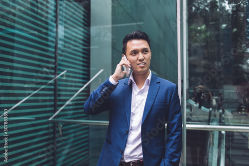 Asian businessman talking on phone in office building