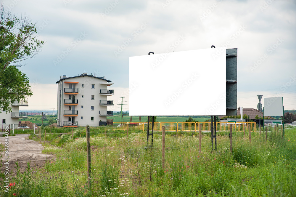 Blank white advertising billboard in the front of construction site on residential area Blank white advertising billboard in the front of construction site on residential area