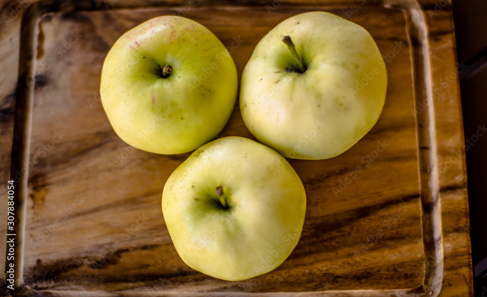 Three green organic healthy apples on wooden board. Three green organic healthy apples on wooden board.